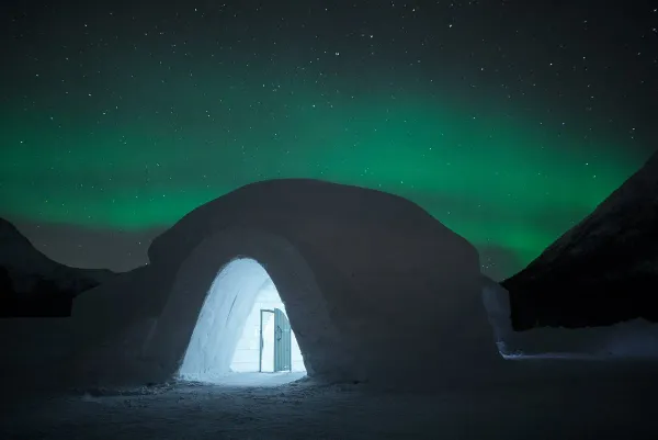 Tromsø Ice Domes glowing under Northern Lights in Tamokdalen Norway