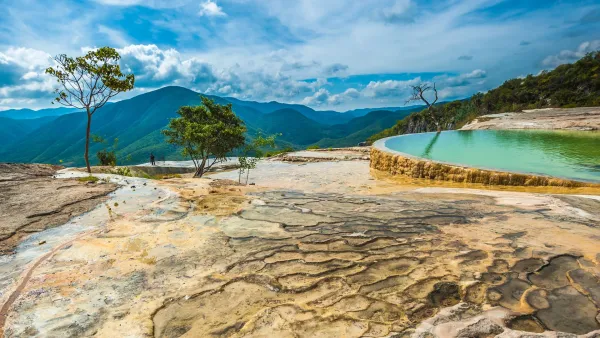 Turquoise mineral pools at Hierve el Agua Oaxaca Mexico perched on limestone cliffs overlooking lush green mountains